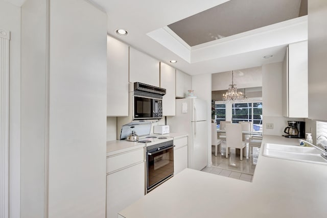 kitchen with sink, decorative light fixtures, white cabinetry, range with electric stovetop, and an inviting chandelier