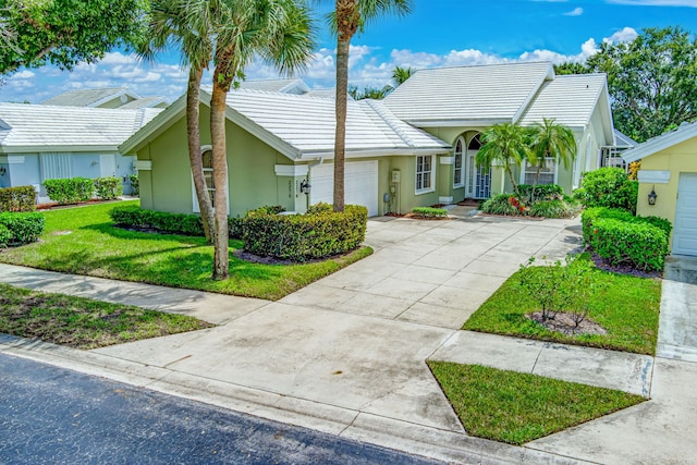 single story home featuring a garage and a front lawn