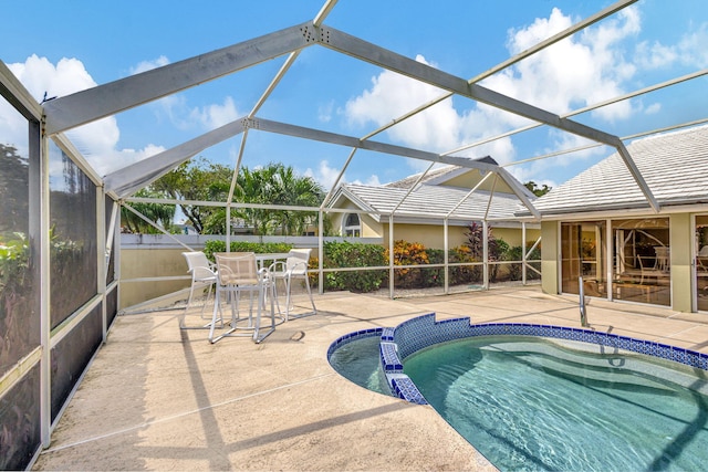 view of swimming pool featuring glass enclosure and a patio area