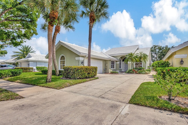 single story home with a front yard and a garage