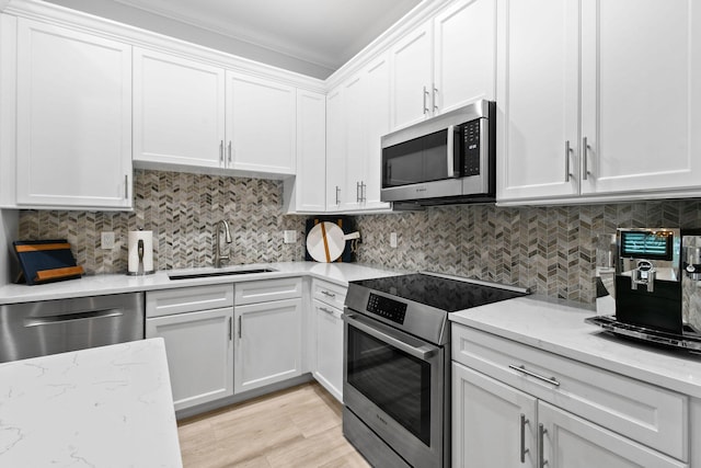 kitchen with sink, white cabinets, stainless steel appliances, and tasteful backsplash