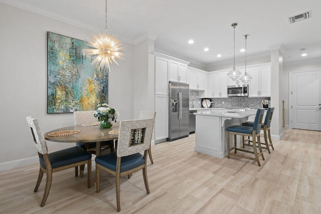 kitchen featuring decorative light fixtures, white cabinets, an inviting chandelier, and appliances with stainless steel finishes