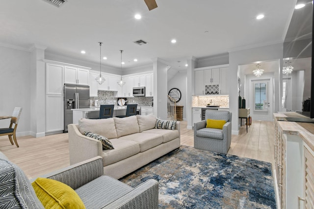 living room with light hardwood / wood-style flooring and ornamental molding