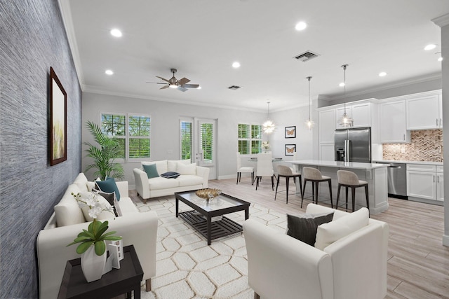 living room featuring ceiling fan, crown molding, and light wood-type flooring