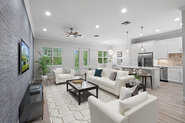 living room with light hardwood / wood-style flooring, ceiling fan, and ornamental molding