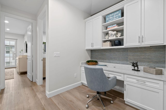 office area with built in desk and light hardwood / wood-style floors