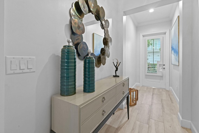 hallway with crown molding and light wood-type flooring