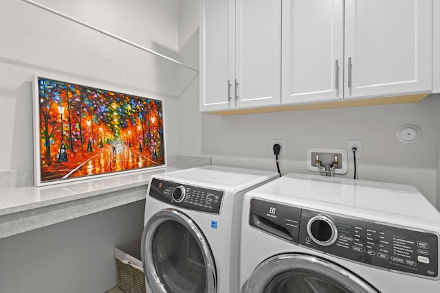 laundry room featuring cabinets and washing machine and clothes dryer