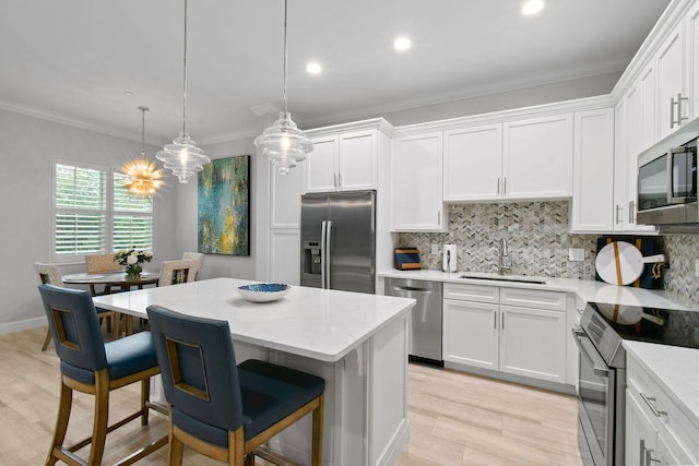 kitchen featuring sink, decorative light fixtures, tasteful backsplash, white cabinetry, and stainless steel appliances