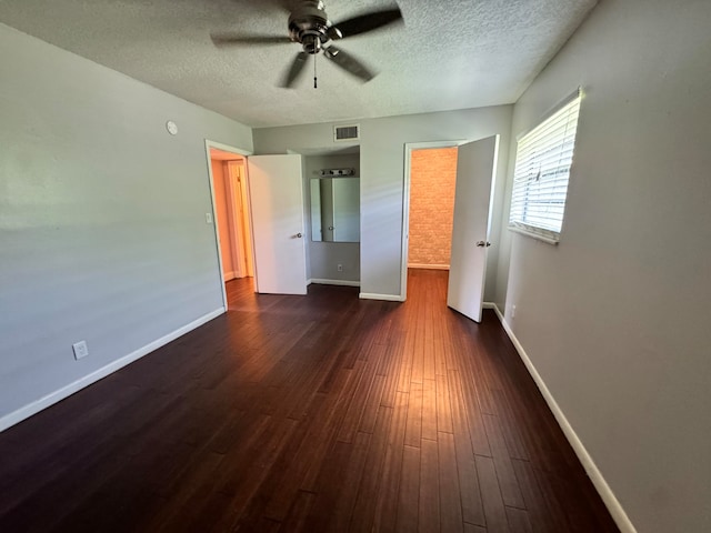 unfurnished bedroom featuring a textured ceiling, ceiling fan, and dark wood-type flooring