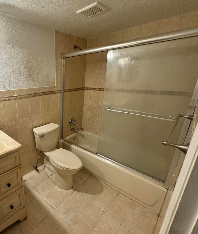 full bathroom featuring shower / bath combination with glass door, vanity, toilet, and tile patterned floors