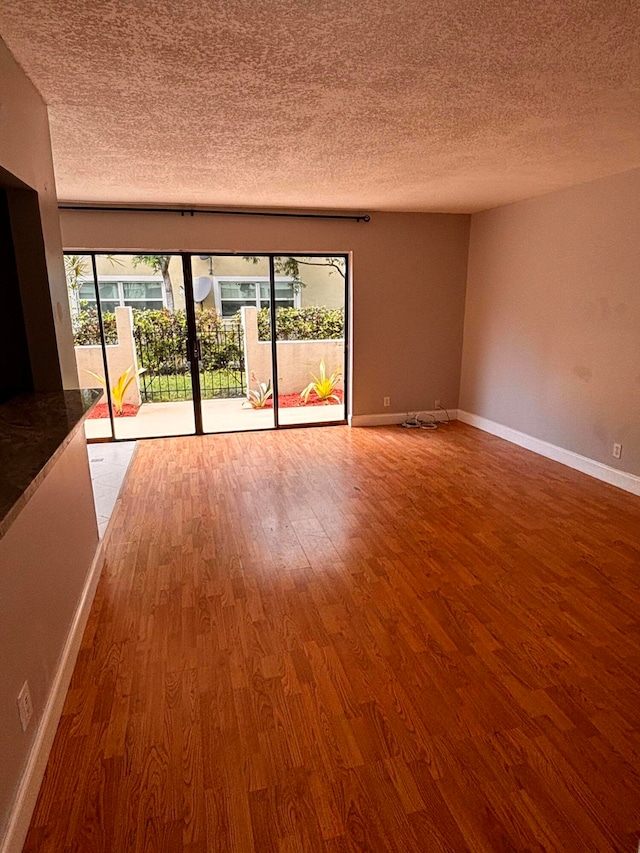 spare room with hardwood / wood-style flooring and a textured ceiling