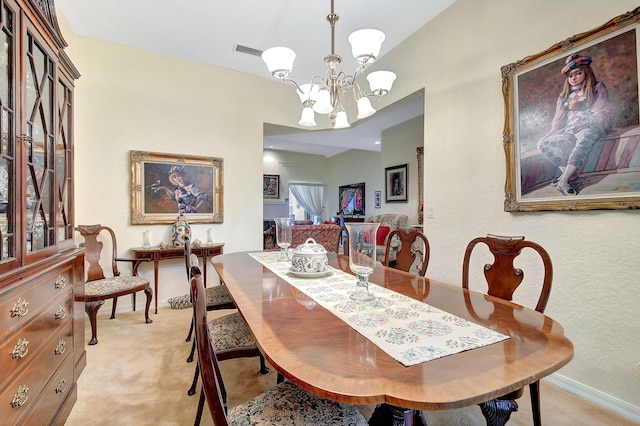dining room featuring a notable chandelier, visible vents, a textured wall, baseboards, and light colored carpet