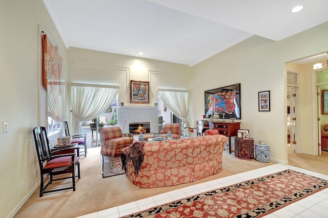 tiled living room with baseboards, recessed lighting, and a glass covered fireplace