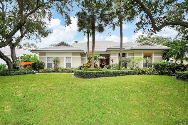 single story home with stucco siding, a tiled roof, and a front yard