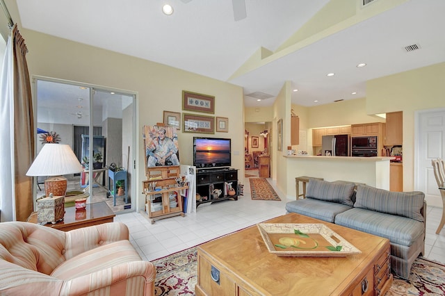 living room with ceiling fan, lofted ceiling, and light tile patterned flooring