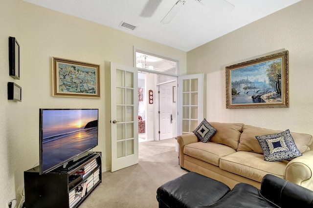 living area featuring light colored carpet, visible vents, french doors, and a ceiling fan