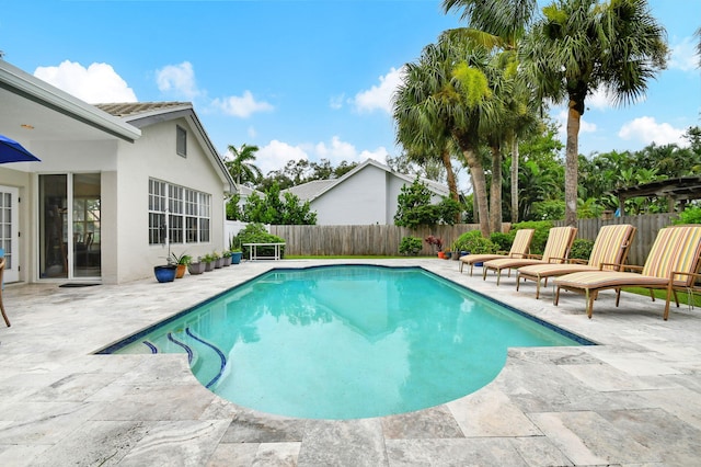 view of swimming pool featuring a fenced in pool, a fenced backyard, and a patio area