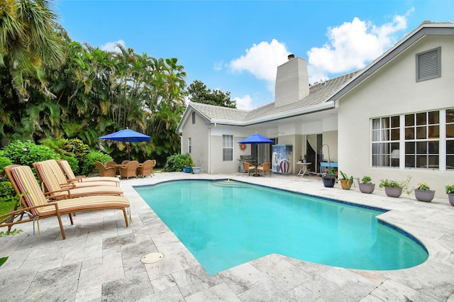 pool with a patio and outdoor dining area