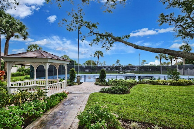 view of home's community with a gazebo, a lawn, and tennis court