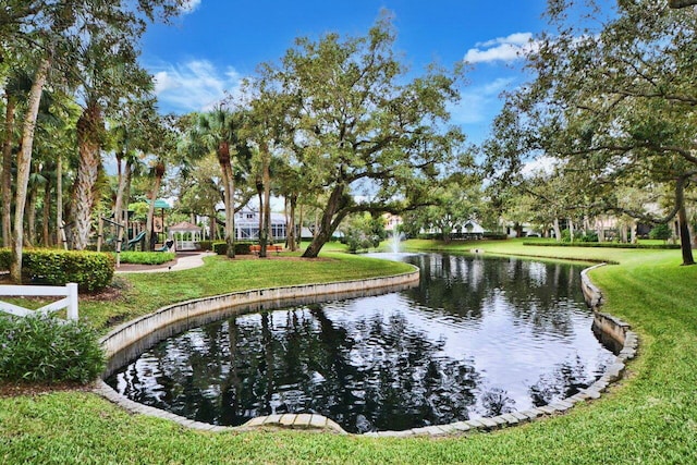 view of community with a water view, a lawn, and a playground