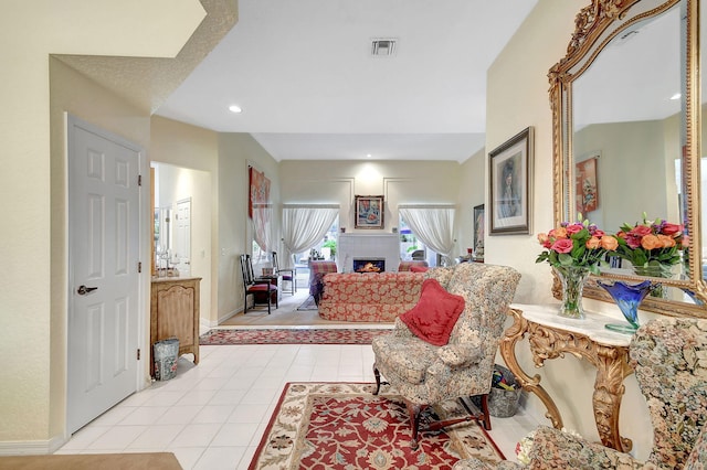 interior space featuring recessed lighting, a warm lit fireplace, light tile patterned flooring, visible vents, and baseboards