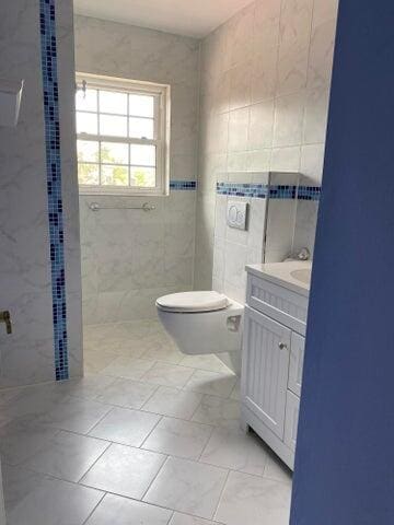 bathroom with vanity, tile walls, toilet, and tile patterned floors