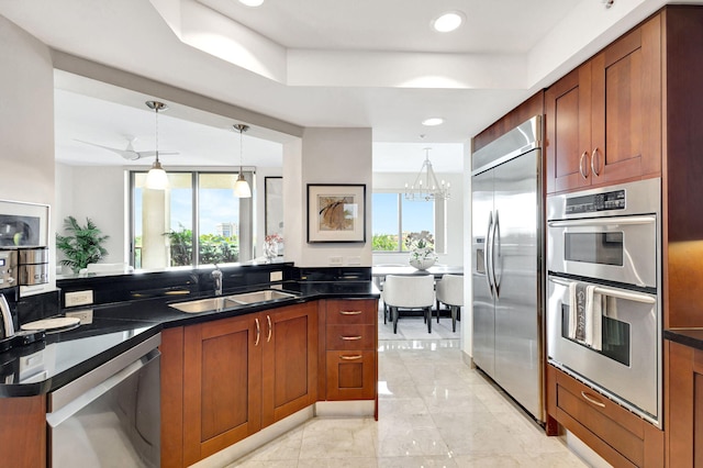 kitchen with pendant lighting, stainless steel appliances, a healthy amount of sunlight, and sink