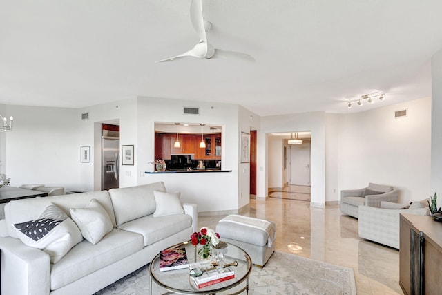 living room with ceiling fan with notable chandelier