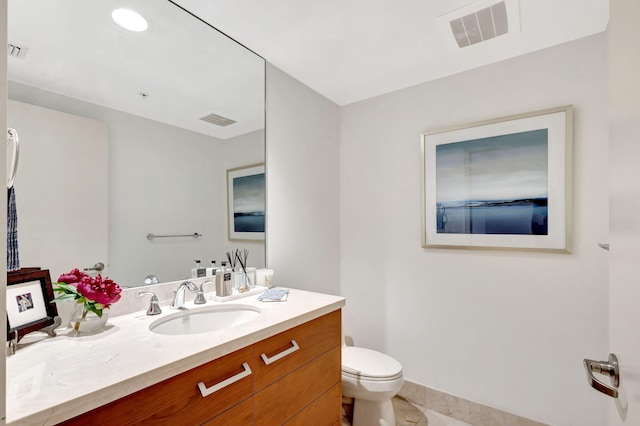 bathroom featuring tile patterned flooring, vanity, and toilet