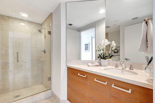 bathroom with walk in shower, vanity, and tile patterned floors