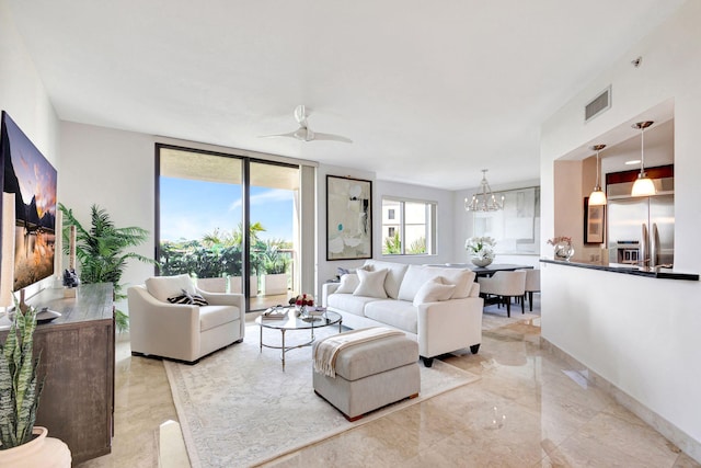 living room featuring ceiling fan with notable chandelier