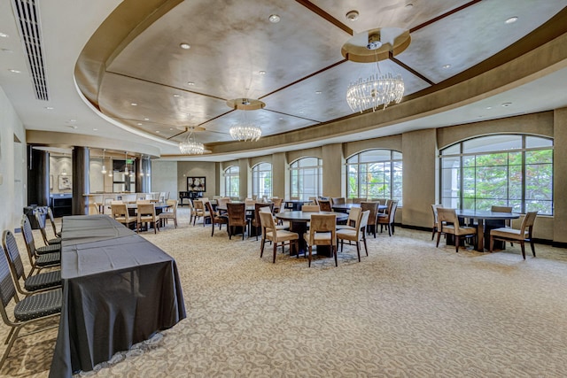 dining area featuring a chandelier, carpet flooring, and a tray ceiling