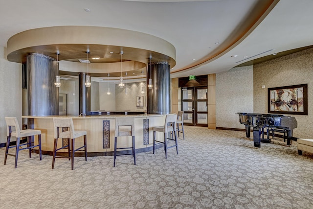 bar featuring pendant lighting, light colored carpet, and a raised ceiling