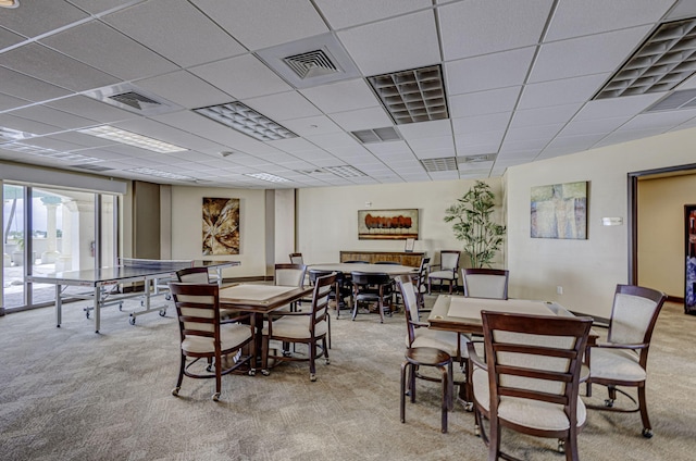 carpeted dining space featuring a paneled ceiling