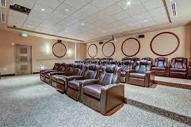 carpeted cinema room featuring a drop ceiling