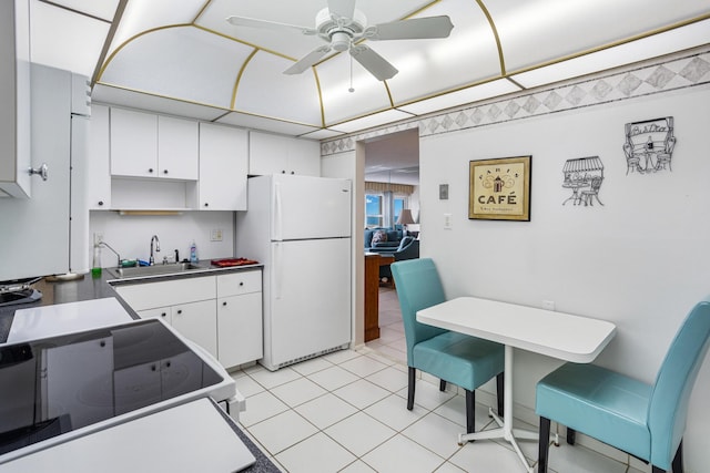 kitchen with white cabinetry, ceiling fan, white fridge, and sink