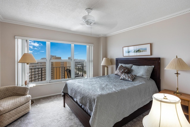 bedroom with ornamental molding, ceiling fan, carpet floors, and a textured ceiling