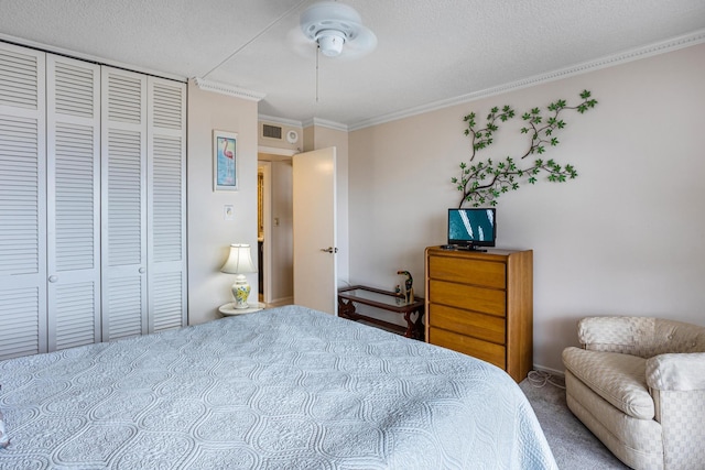 bedroom with a closet, a textured ceiling, ceiling fan, carpet, and ornamental molding