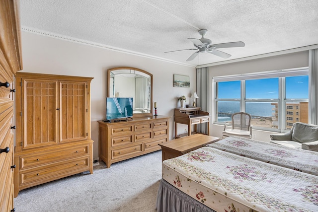 carpeted bedroom with ceiling fan and a textured ceiling