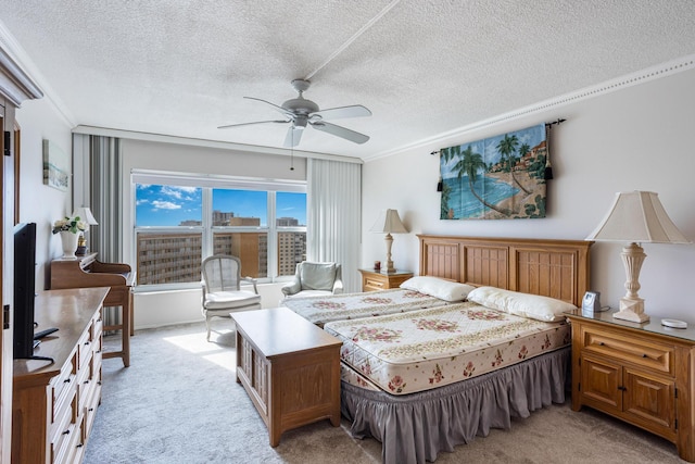 bedroom featuring ceiling fan, a textured ceiling, light carpet, and ornamental molding