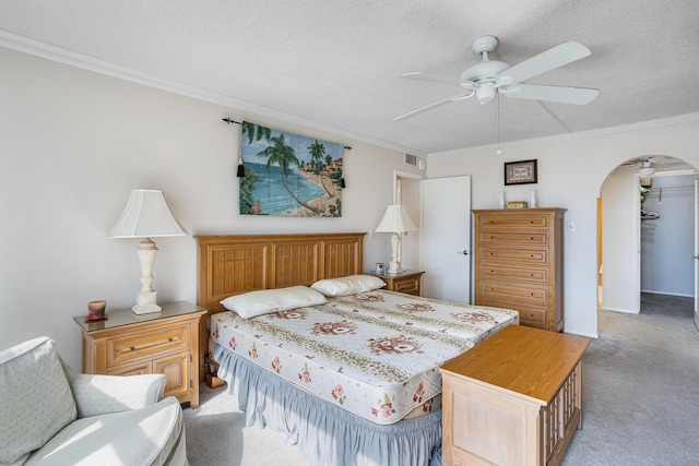 carpeted bedroom featuring ceiling fan, a textured ceiling, and ornamental molding