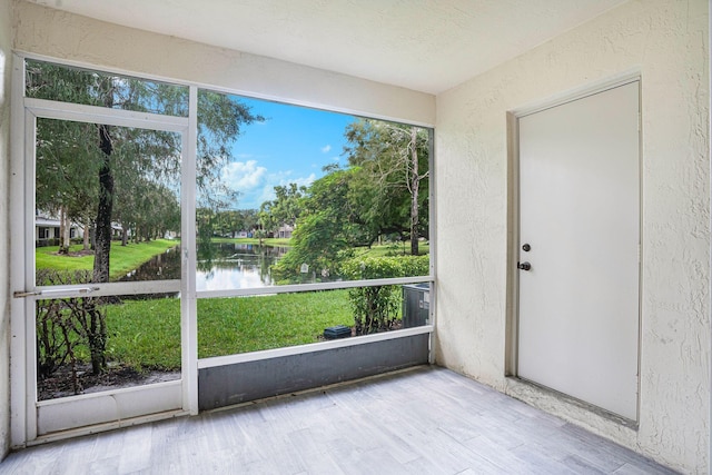 unfurnished sunroom featuring a water view