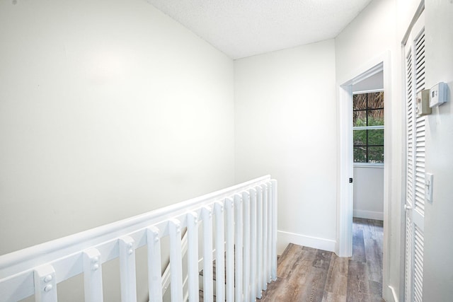 hallway with wood-type flooring and a textured ceiling