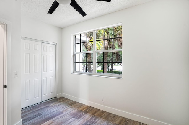 unfurnished bedroom featuring a textured ceiling, hardwood / wood-style floors, ceiling fan, and a closet