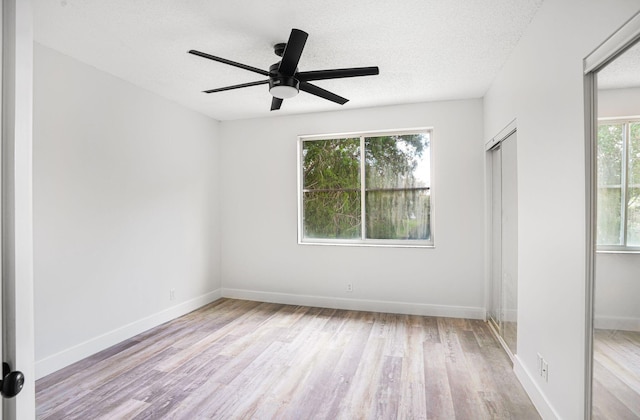 unfurnished bedroom with multiple windows, light hardwood / wood-style floors, and ceiling fan