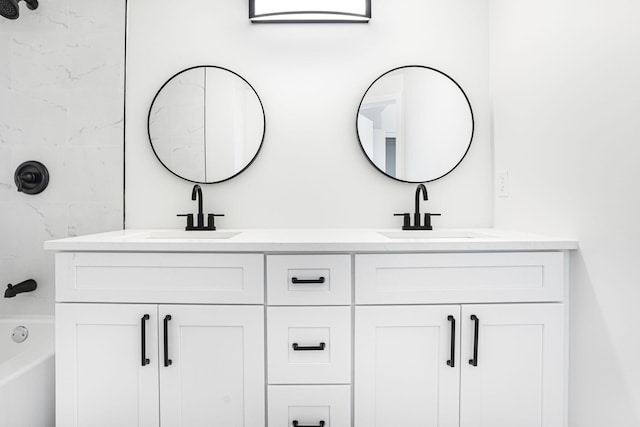 bathroom featuring tiled shower / bath combo and vanity