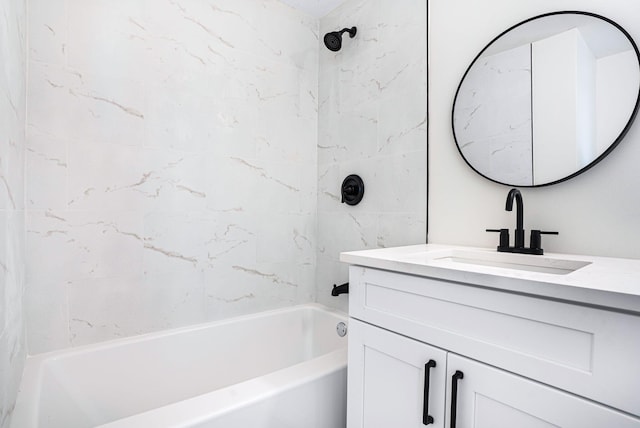 bathroom featuring tiled shower / bath combo and vanity