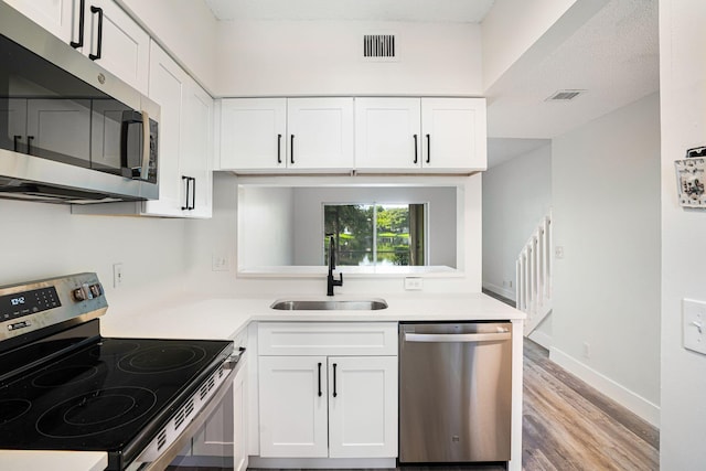 kitchen featuring white cabinets, light hardwood / wood-style floors, stainless steel appliances, and sink