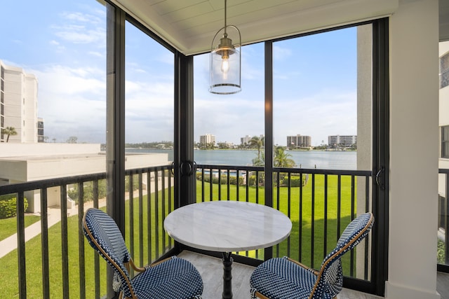 sunroom / solarium featuring a water view